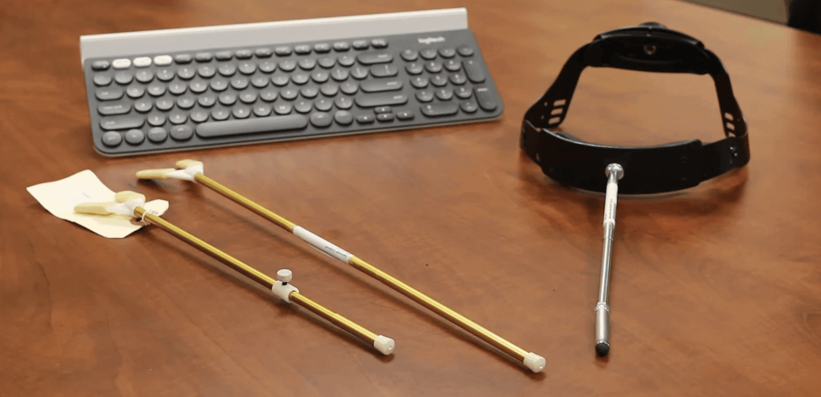 A set of assistive tools, including a keyboard, a mouth stick, and a head wand.